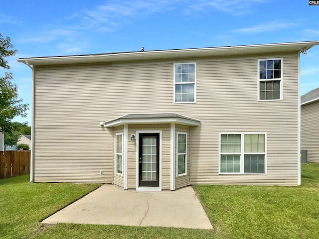 rear view of house featuring a lawn and a patio