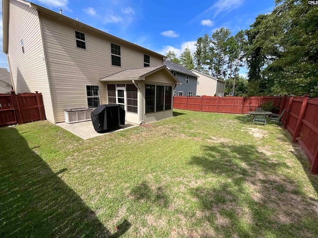 rear view of property with a yard, a sunroom, and a patio area