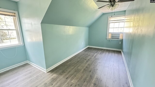 additional living space featuring lofted ceiling, ceiling fan, a wealth of natural light, and wood-type flooring