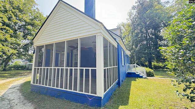 view of side of property with a lawn and a sunroom