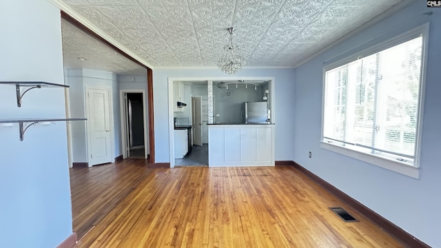 1926 Middleton St, Orangeburg, SC 29115 - unfurnished living room with visible vents, baseboards, ornamental molding, wood finished floors, and an ornate ceiling