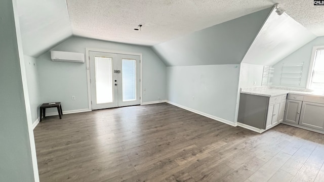 bonus room featuring vaulted ceiling, a textured ceiling, and light hardwood / wood-style flooring