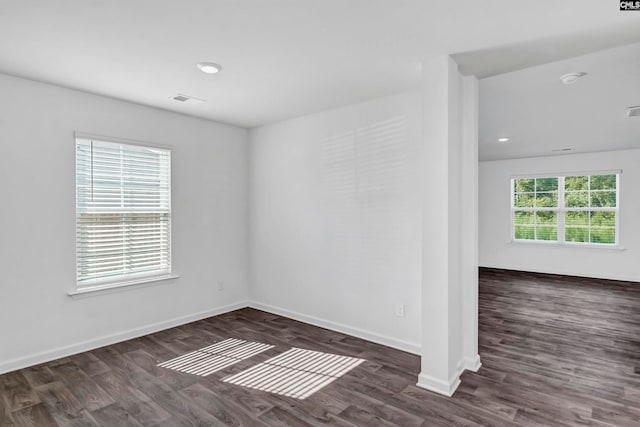 unfurnished room with dark wood-type flooring and a wealth of natural light