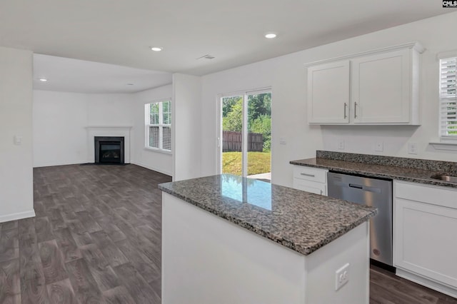 kitchen featuring dishwasher, dark stone counters, white cabinetry, and a kitchen island