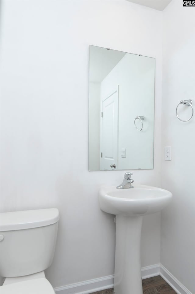 bathroom with toilet, hardwood / wood-style flooring, and sink