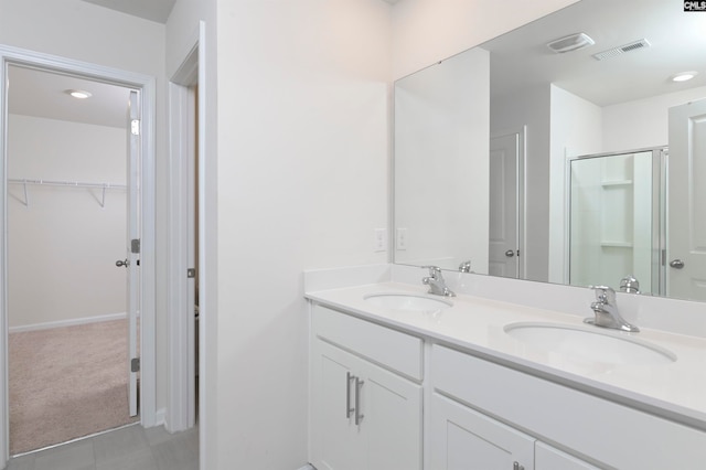 bathroom with tile patterned floors, walk in shower, and vanity