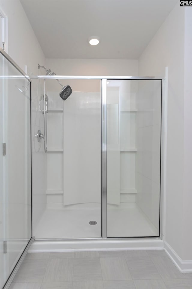 bathroom with tile patterned flooring and a shower with shower door