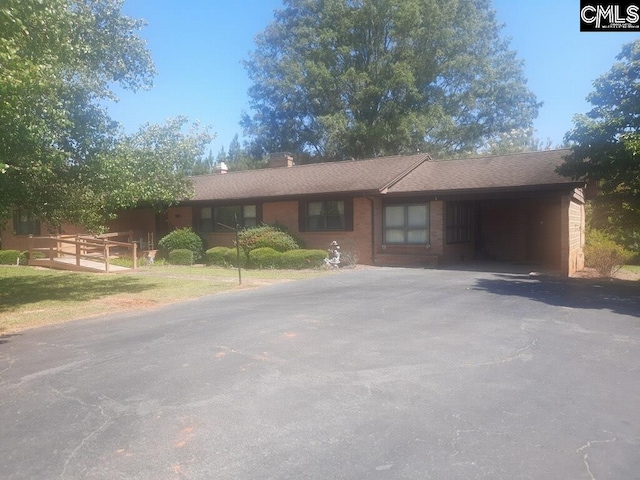 ranch-style house with a carport and a front lawn