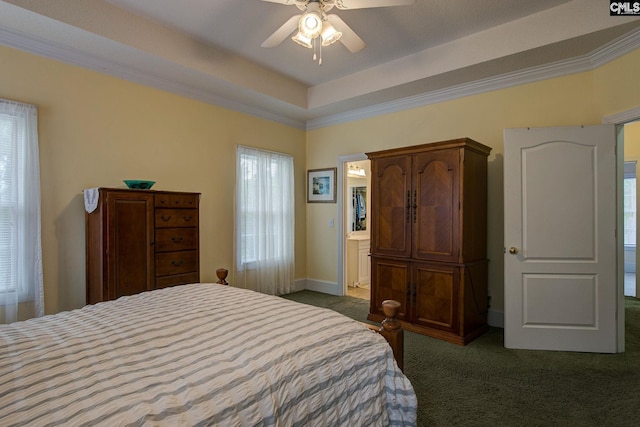 carpeted bedroom featuring ensuite bath, multiple windows, and ceiling fan