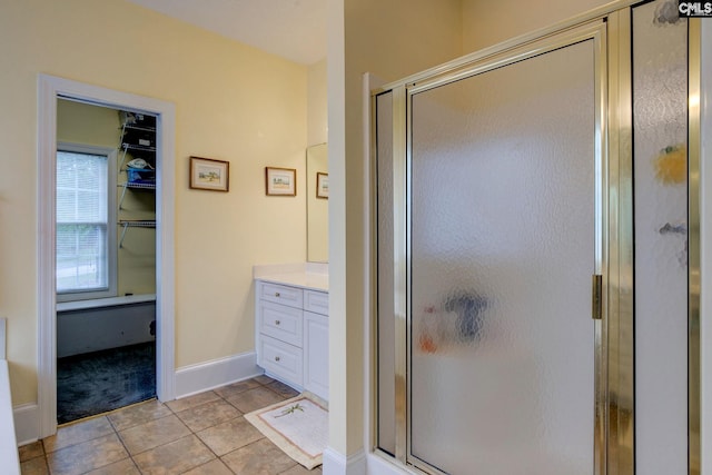 bathroom featuring tile patterned floors, a shower with door, and vanity