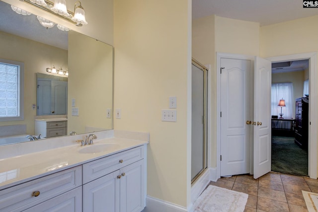 bathroom with vanity, a shower with shower door, and tile patterned floors