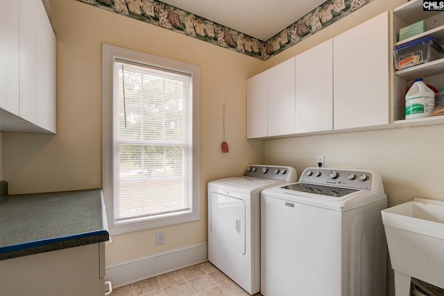 laundry area featuring a wealth of natural light, cabinets, washer and clothes dryer, and light tile patterned floors