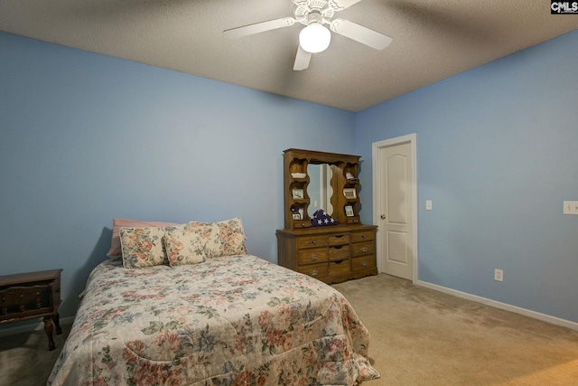 carpeted bedroom featuring a textured ceiling and ceiling fan