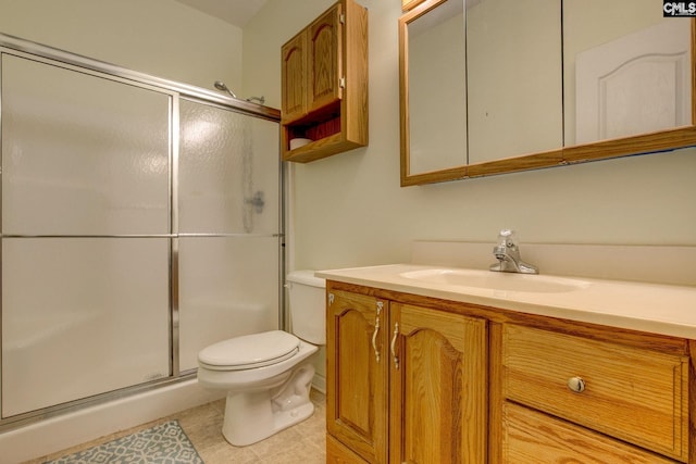 bathroom with tile patterned flooring, vanity, toilet, and a shower with shower door