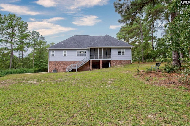 back of house featuring a lawn and a sunroom