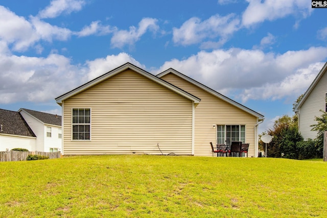 back of property featuring a patio area, a lawn, and fence