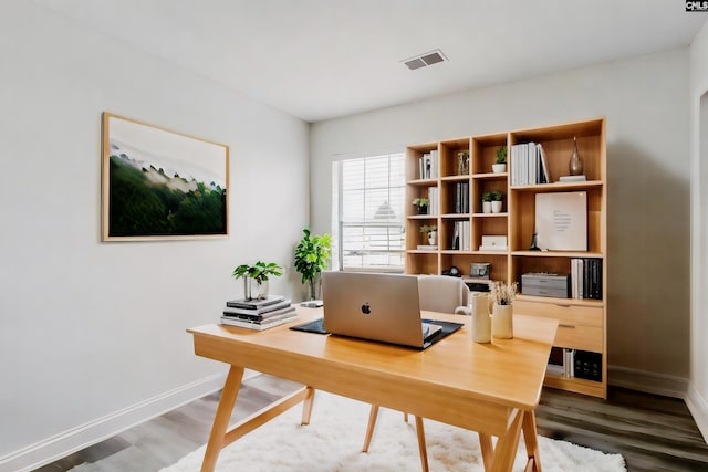 home office with wood finished floors, visible vents, and baseboards