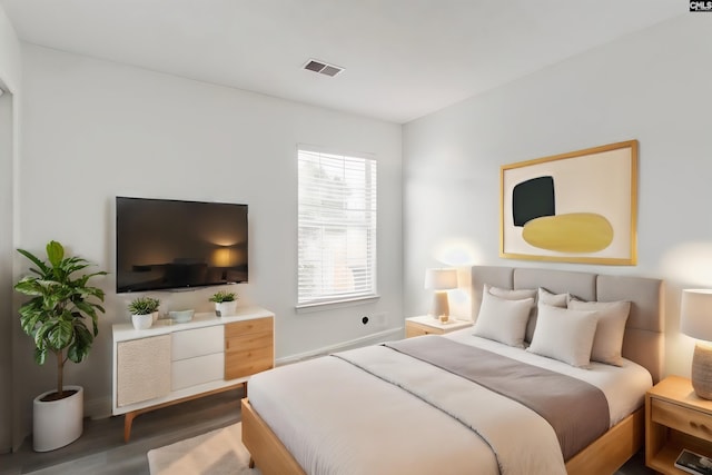 bedroom featuring visible vents and wood finished floors