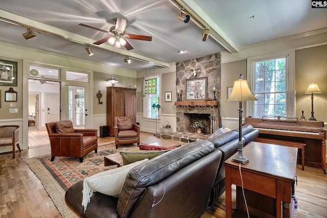 living room featuring a fireplace, plenty of natural light, ceiling fan, and light hardwood / wood-style floors