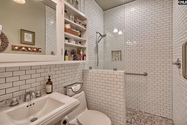 bathroom featuring toilet, tiled shower, sink, decorative backsplash, and tile walls