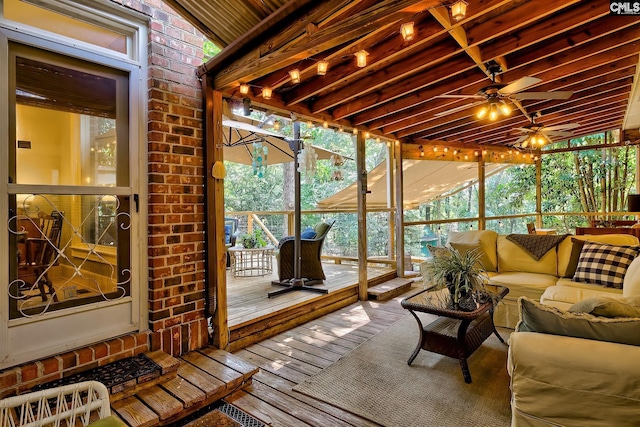 sunroom / solarium featuring a healthy amount of sunlight and ceiling fan