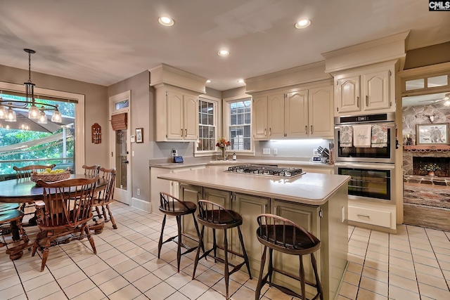 kitchen featuring appliances with stainless steel finishes, a wealth of natural light, a center island, and hanging light fixtures