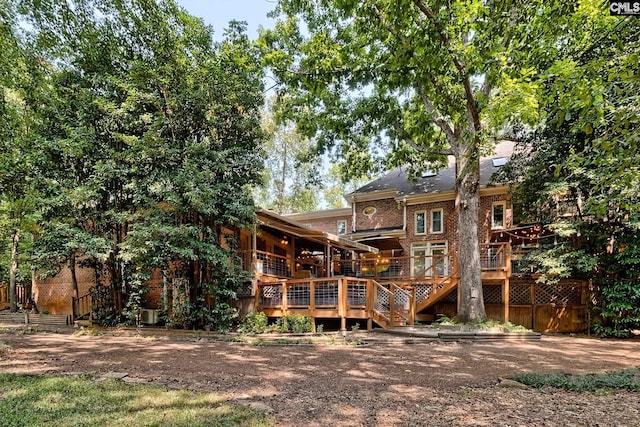 rear view of property featuring a wooden deck