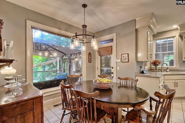 tiled dining area with sink and an inviting chandelier