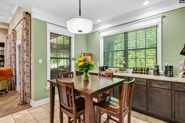 dining room with crown molding and light hardwood / wood-style flooring