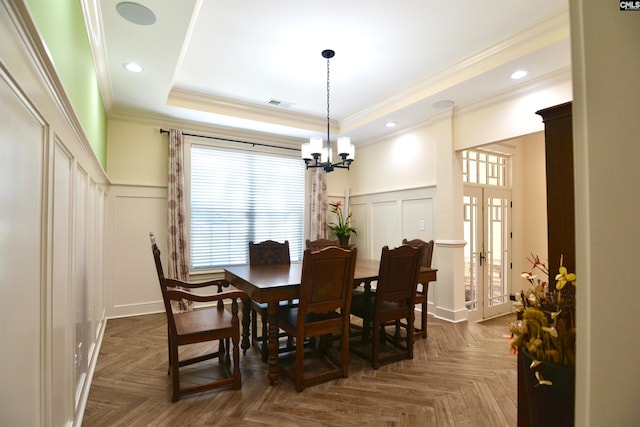 dining area featuring dark parquet flooring, a chandelier, and ornamental molding