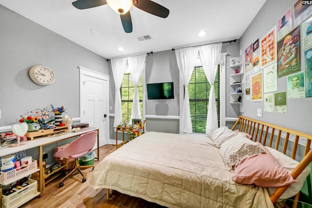 bedroom featuring multiple windows, wood-type flooring, and ceiling fan