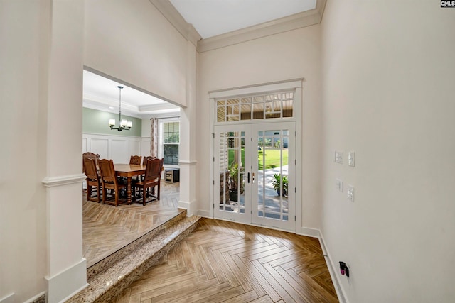 doorway to outside featuring a chandelier, parquet flooring, and ornamental molding