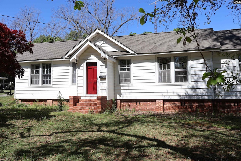 view of front facade with entry steps, a front lawn, roof with shingles, and crawl space