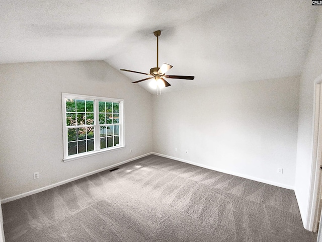 carpeted spare room with ceiling fan, a textured ceiling, and vaulted ceiling