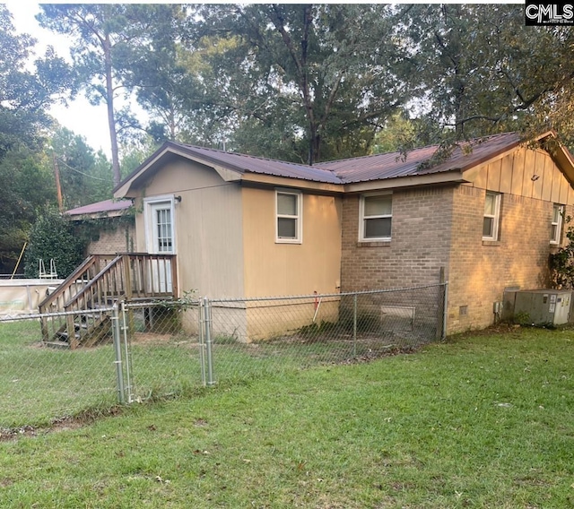 view of home's exterior with central AC, crawl space, a lawn, metal roof, and fence