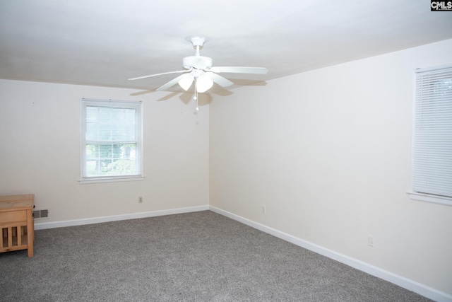 empty room featuring ceiling fan and carpet