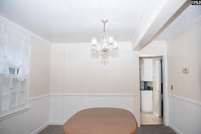 dining area featuring light colored carpet, ornamental molding, and an inviting chandelier