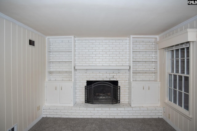 unfurnished living room featuring a fireplace, crown molding, and carpet floors