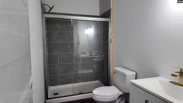 bathroom with an enclosed shower, vanity, and toilet