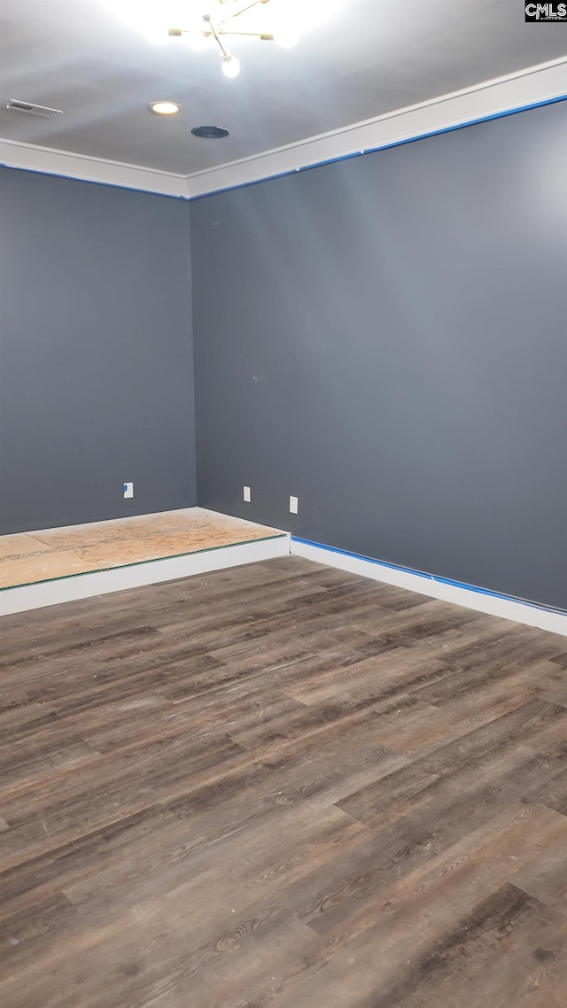 unfurnished room featuring dark wood-type flooring and crown molding