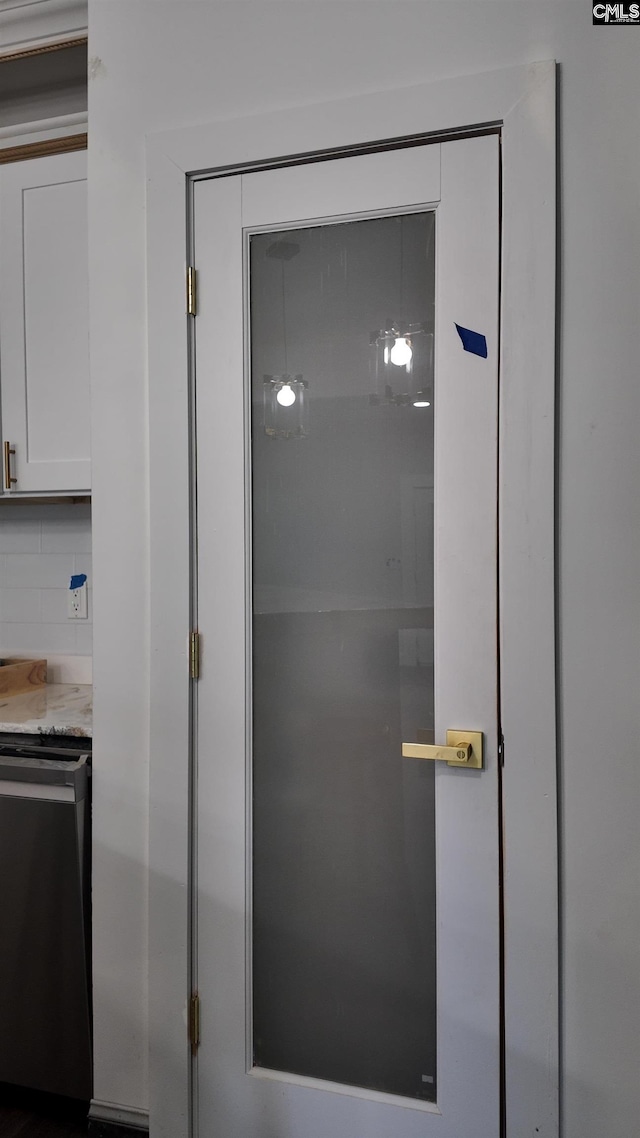 details featuring decorative backsplash and stainless steel dishwasher