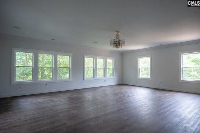 unfurnished room featuring ornamental molding, a chandelier, and dark hardwood / wood-style floors