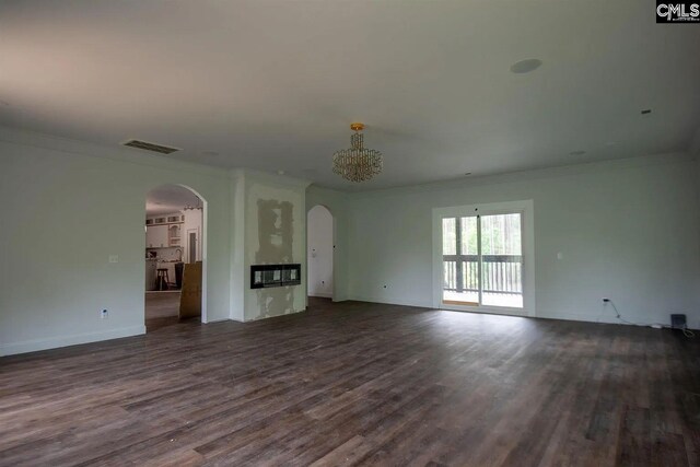 205 Miles Oak Ln, Blythewood, SC 29016 - unfurnished living room featuring visible vents, baseboards, arched walkways, ornamental molding, and dark wood finished floors