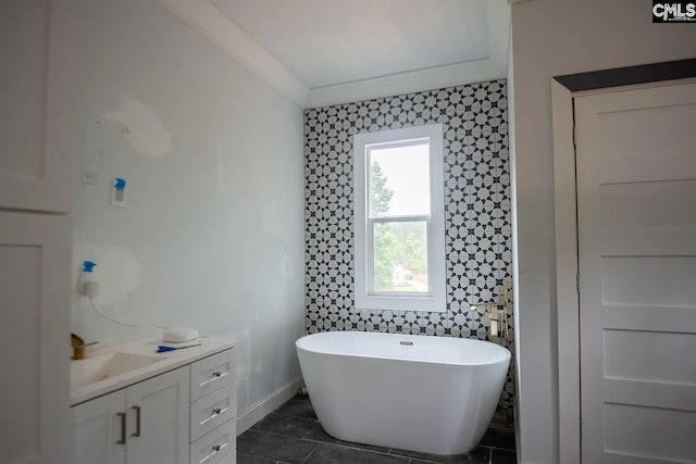 bathroom with tile walls, tile patterned flooring, a tub to relax in, crown molding, and vanity