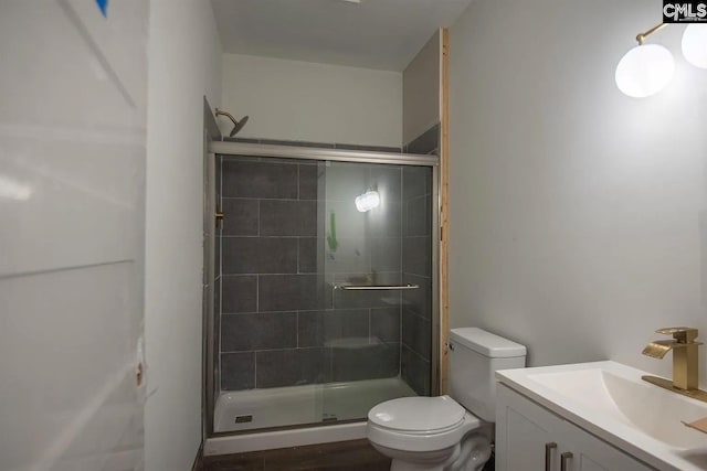 bathroom with vanity, toilet, and an enclosed shower