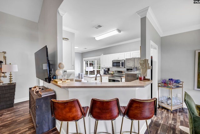 kitchen with stainless steel appliances, kitchen peninsula, dark hardwood / wood-style floors, and white cabinets