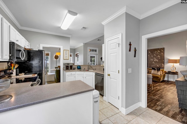 kitchen with ornamental molding, sink, white cabinets, appliances with stainless steel finishes, and light hardwood / wood-style floors