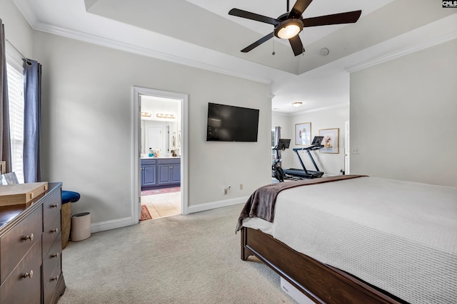 carpeted bedroom featuring ensuite bath, crown molding, a tray ceiling, and ceiling fan