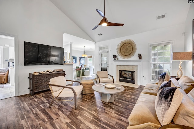 living room with ceiling fan, high vaulted ceiling, wood-type flooring, and a fireplace