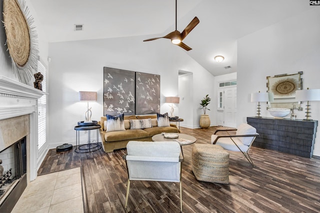 living room with hardwood / wood-style floors, high vaulted ceiling, a fireplace, and ceiling fan